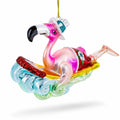 Pink Flamingo Riding a Surf Wave Glass Christmas Ornament
